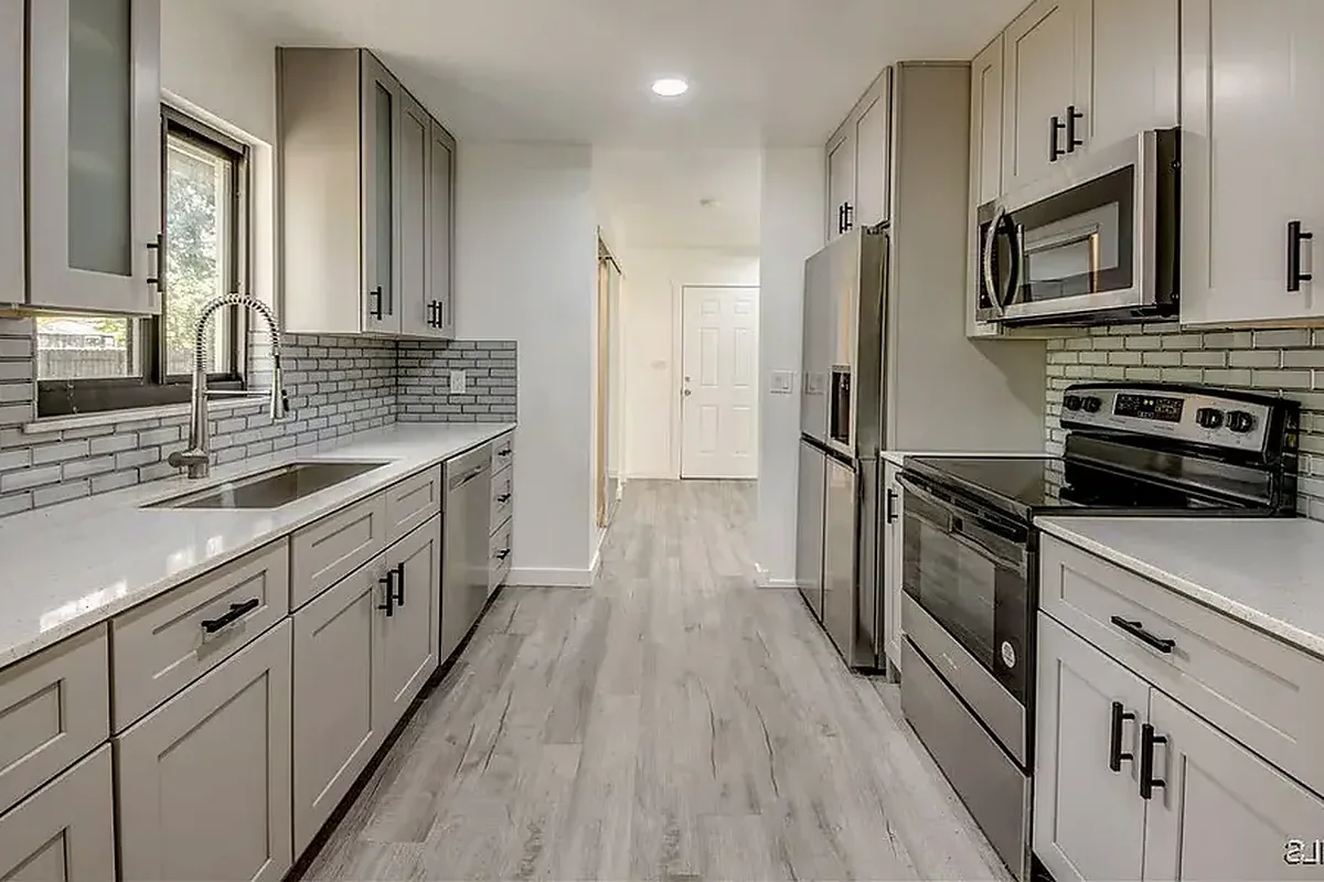 Southwest Florida finished flooring example: Kitchen floors must be completed around cabinets, walls, appliances and connections to nearby rooms.